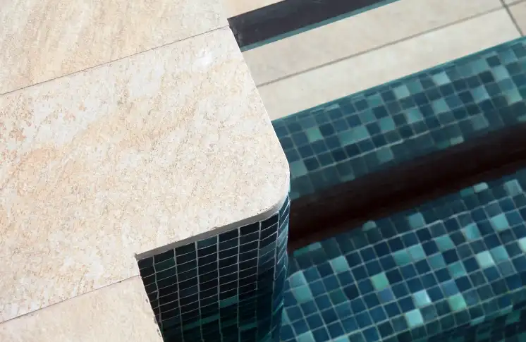 Borde de piscina con pavimento de piedra y gresite verde