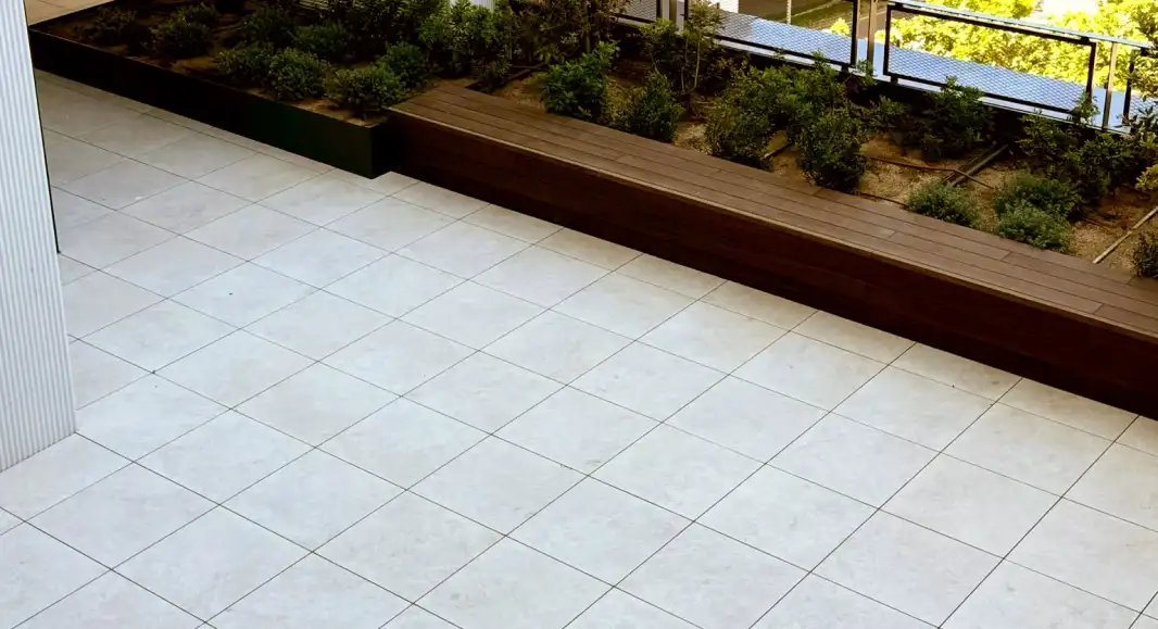 Terraza con jardinera de madera y pavimento claro