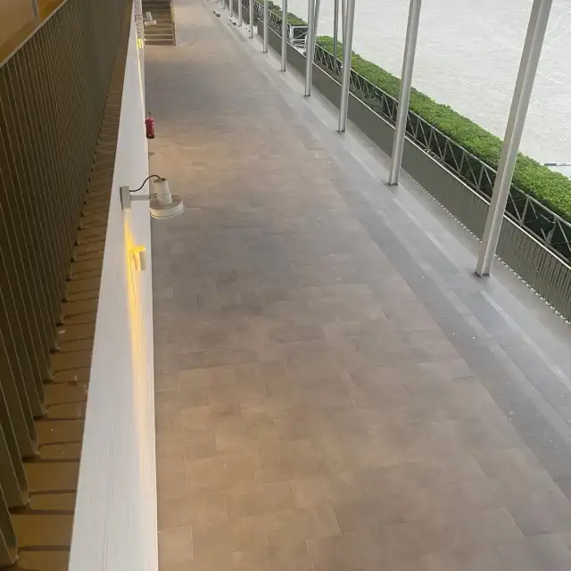 Pasillo exterior cubierto con pavimento gris