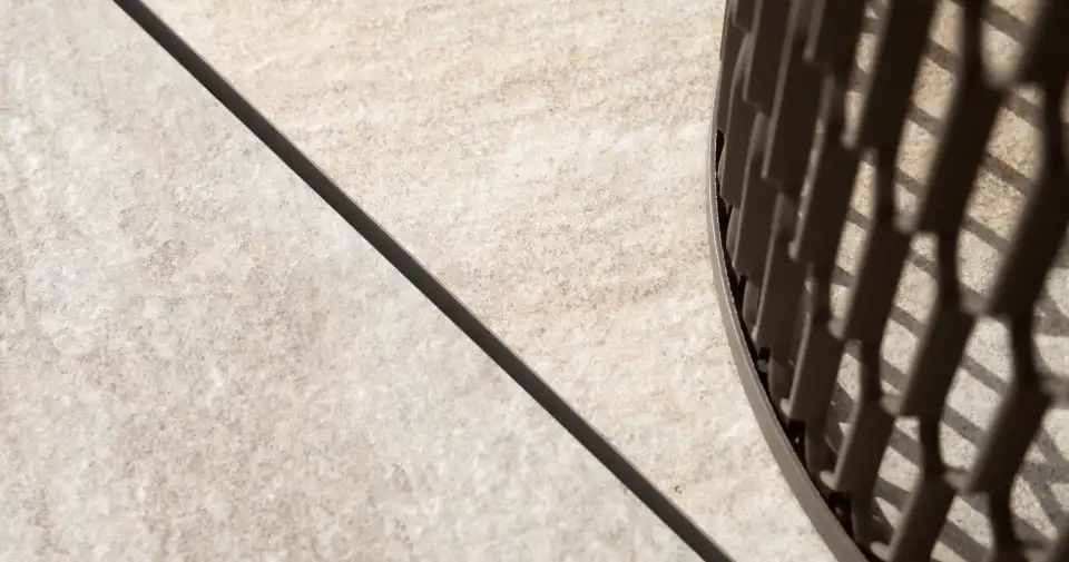 Pavimento de piedra con la sombra de una barandilla curva